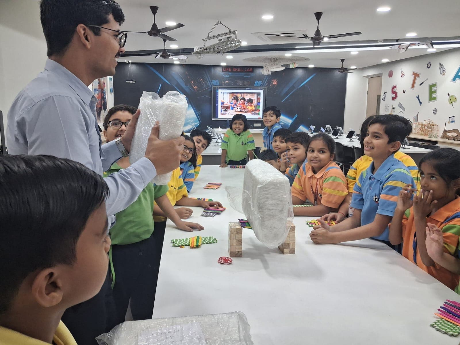 A trainer and students gathered around a Take-Away Kit build at an Alforaa Skill Lab